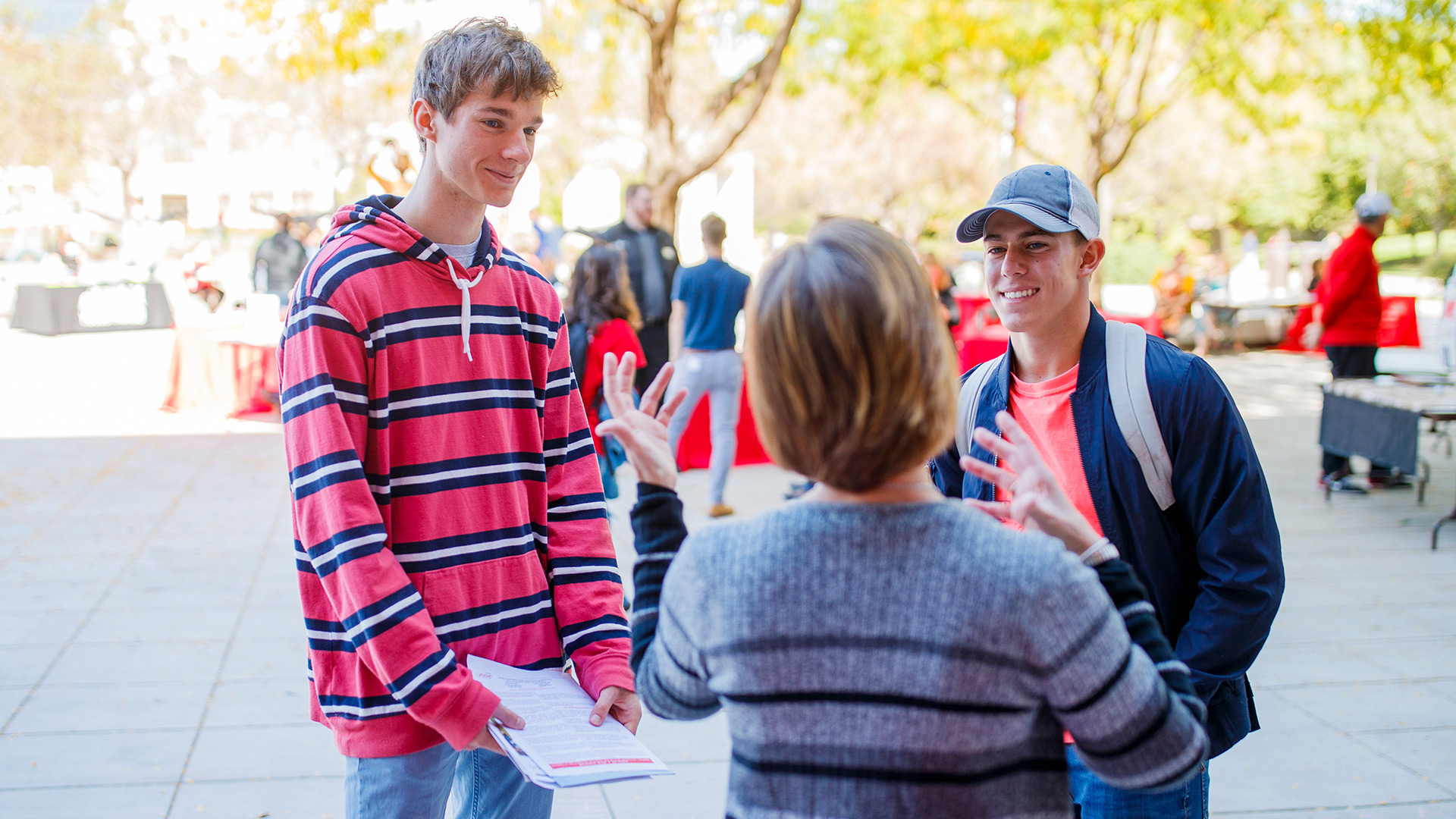 Two students talking to a vendor at a fair