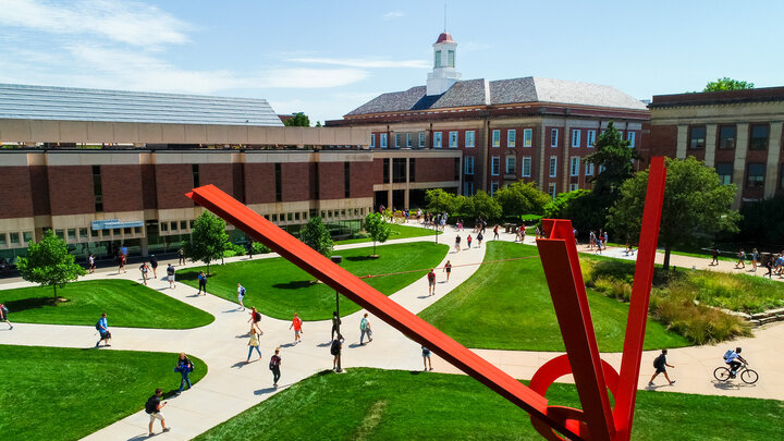 Students cross city campus under the gaze of Old Glory