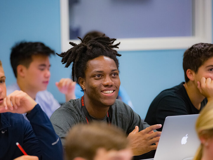 A student smiling while sitting in class