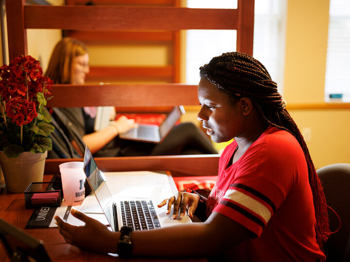 Student working on a computer in her dorm